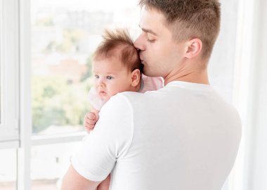 Father kissing infant daughter clipart
