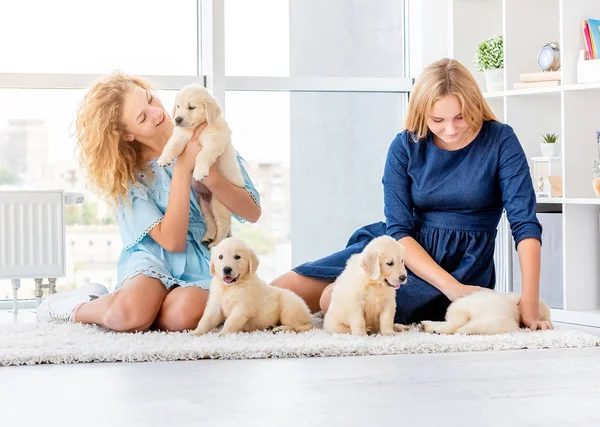 Meisjes spelen met retriever puppies — Stockfoto