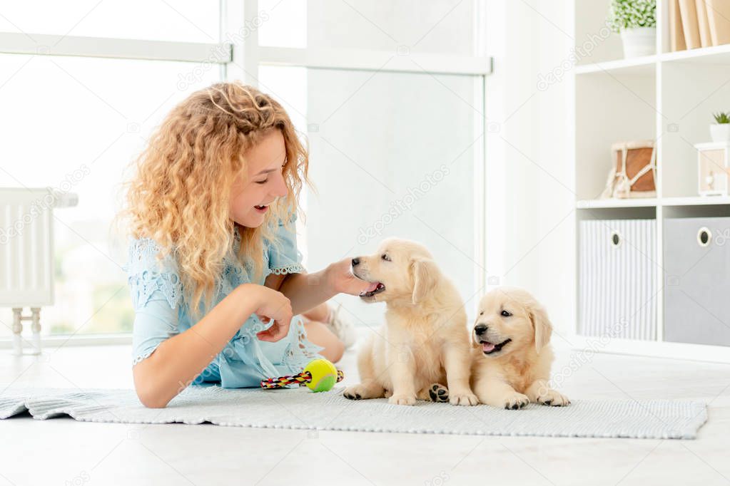 Girl relaxing with retriever puppies