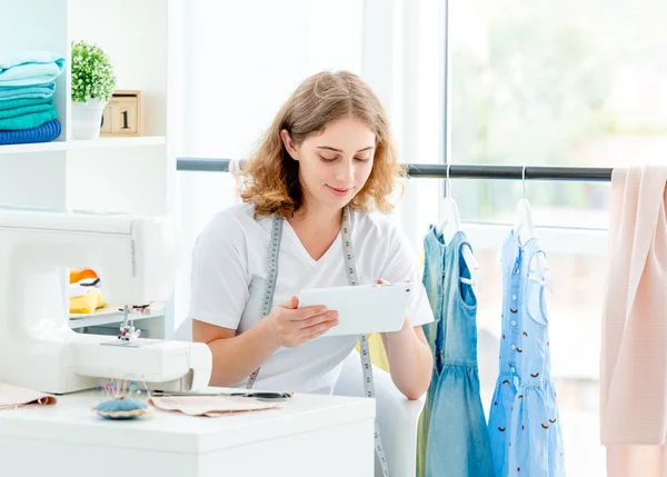 Dressmaker selezionando schizzo su tablet — Foto Stock