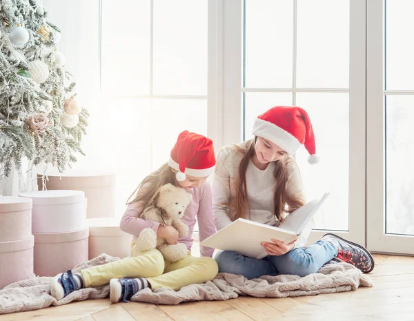 Leende systrar läser bok — Stockfoto