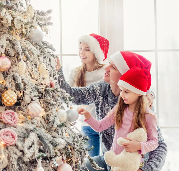 Far och döttrar dekorera julgran — Stockfoto