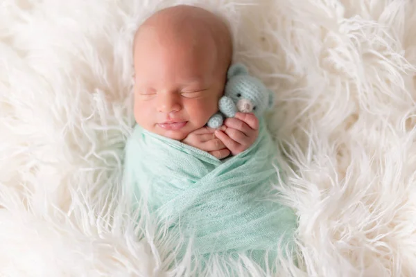 Newborn baby lying with knitted toy — Stock Photo, Image