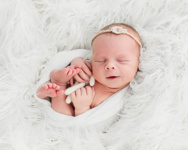 Bebê recém-nascido dormindo com um pequeno brinquedo — Fotografia de Stock