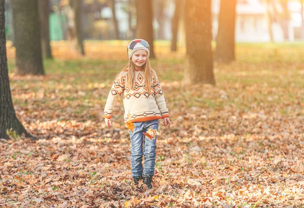 Yaprak halısında yürüyen kız — Stok fotoğraf