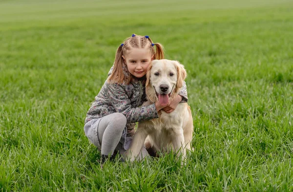 Meisje knuffelende hond op het veld — Stockfoto