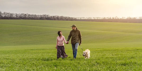 Par som rastar hund på vårfältet — Stockfoto