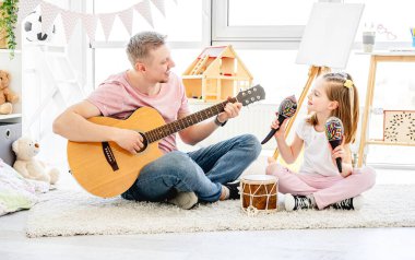 Baba ve kızı müzik aletleri çalıyorlar.