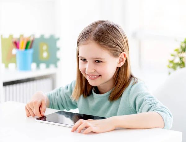 Schönes kleines Mädchen neben Tablet — Stockfoto