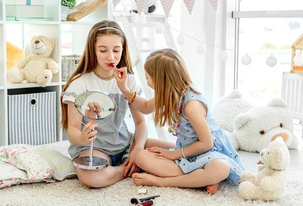 Crianças felizes brincando com batom de maquiagem — Fotografia de Stock