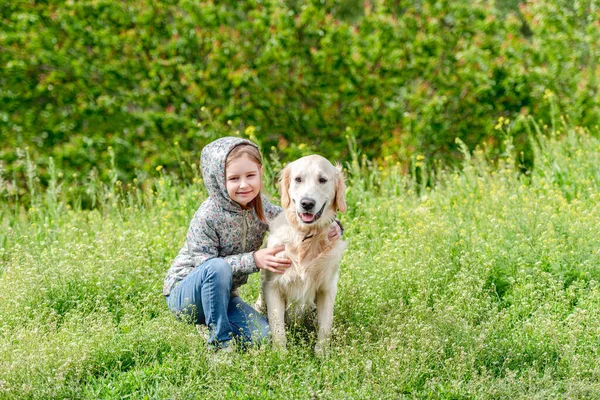 Gelukkig klein meisje knuffelen schattig hond — Stockfoto