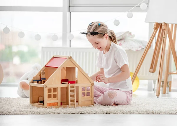 Hübsches kleines Mädchen spielt mit Puppenhaus — Stockfoto