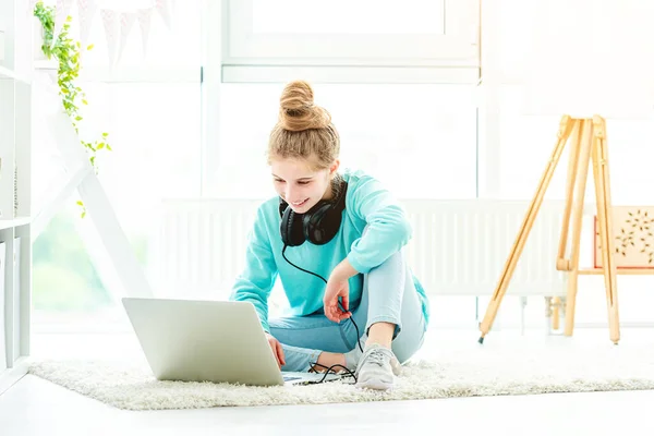 Linda chica usando el ordenador portátil en habitación luminosa —  Fotos de Stock