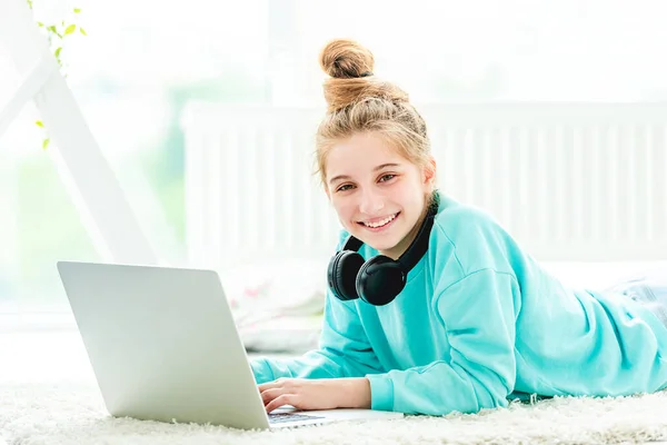 Cheerful girl with laptop and headphones — Stock Photo, Image