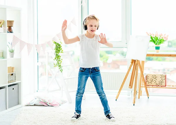 Pretty little girl dancing wearing headphones — Stock Photo, Image