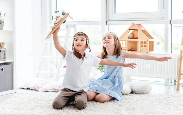 Счастливые дети играют с моделью самолета — стоковое фото