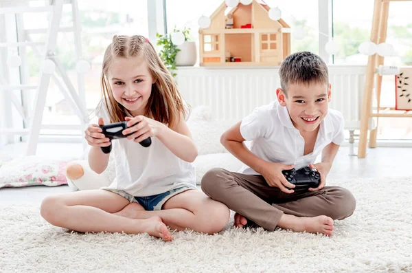 小男孩和小女孩玩电子游戏 — 图库照片