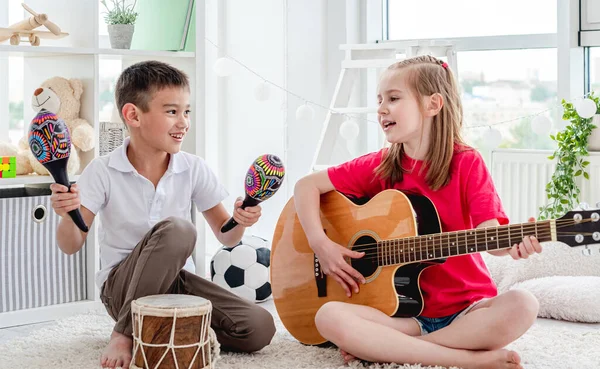 Lächelnde Kinder spielen auf Trommel und Gitarre — Stockfoto