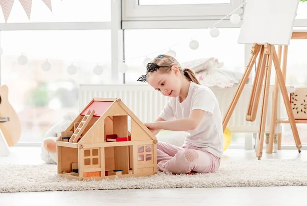 Menina bonita brincando com casa de bonecas — Fotografia de Stock