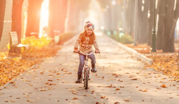 Счастливая девушка на велосипеде в парке — стоковое фото
