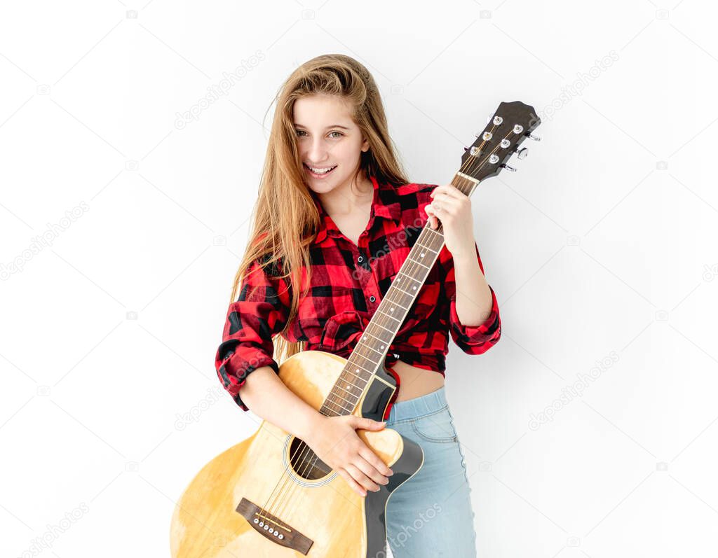 Attractive teenage girl standing with guitar