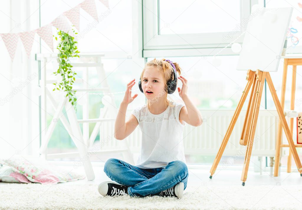Cute little girl in headphones singing