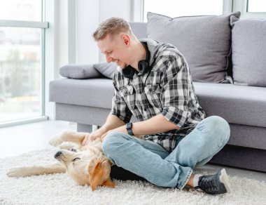 Mutlu adam sevimli köpeği avuçluyor