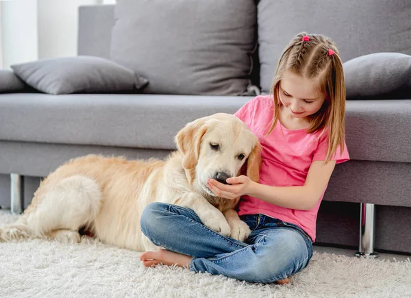Menina brincando com cão em casa — Fotografia de Stock