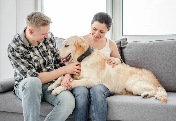 Mujer y hombre abrazando lindo perro — Foto de Stock