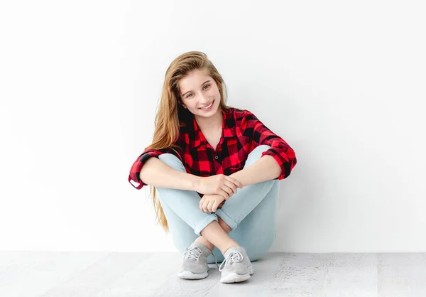 Sonriente adolescente sentada en el suelo — Foto de Stock