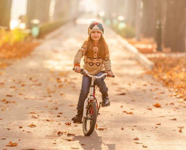 Happy girl riding bike in park — Stock Photo, Image