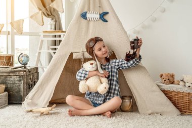 Gülümseyen küçük kız kameraya selfie çekiyor.