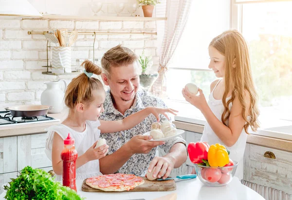 Pai com filhas preparando pizza — Fotografia de Stock