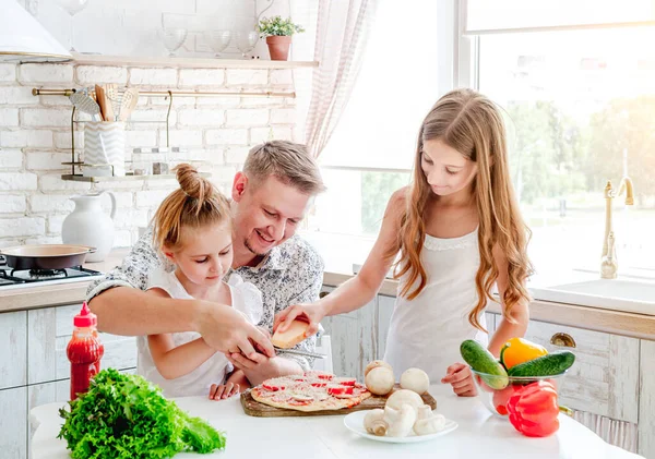 Vater mit Töchtern bereitet Pizza zu — Stockfoto