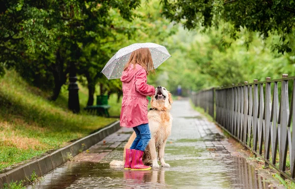 Yağmurda köpekli küçük kız — Stok fotoğraf
