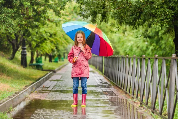 Liten flicka hoppar i pöl — Stockfoto