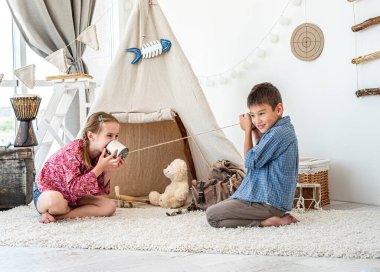 Çocuklar kendi yaptıkları telefonlarla oynuyorlar.