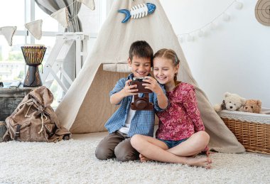 Çocuklar film kamerasında selfie çekiyor.