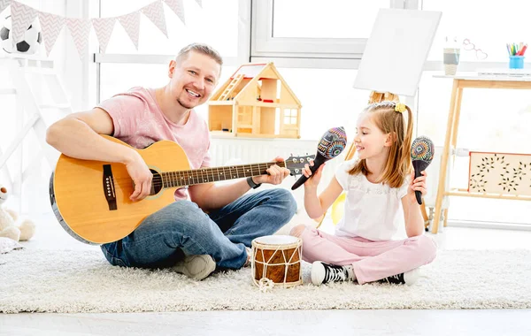 Отец и дочь играют на музыкальных инструментах — стоковое фото