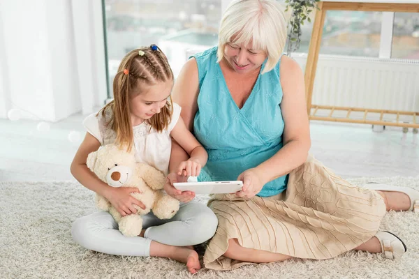 Šťastná babička s vnučkou pomocí tabletu — Stock fotografie