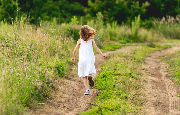 Happy little girl running along path — Stock Photo, Image