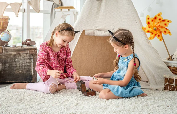 Little girls playing with treasure box