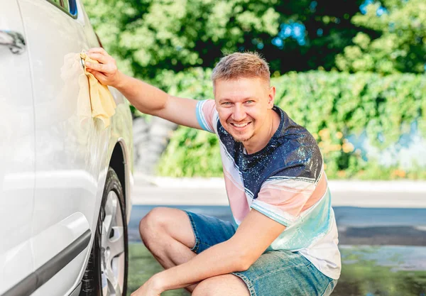 Muž čištění auto s hadrem — Stock fotografie
