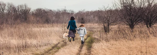 Madre e hija paseando perro — Foto de Stock