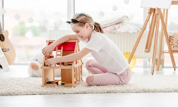 Menina bonita brincando com casa de bonecas — Fotografia de Stock