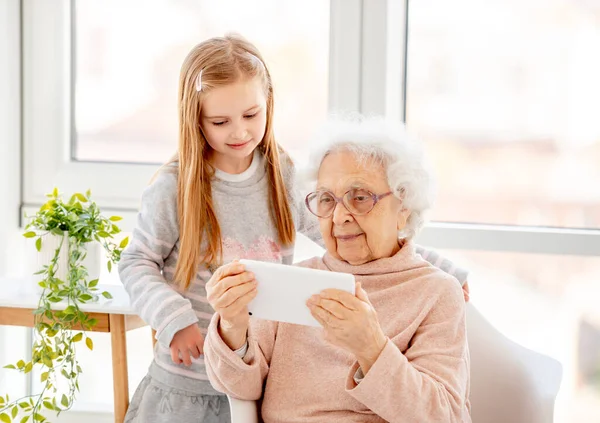 Söt flicka hjälpa gammal dam — Stockfoto