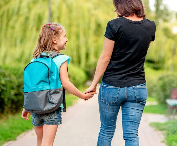 Schoolgirl going home with mother — Stock Photo, Image