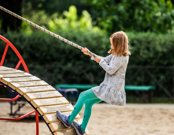 Criança escalando com corda no playground — Fotografia de Stock