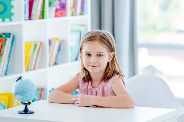 Kleines Mädchen sitzt im hellen Klassenzimmer — Stockfoto