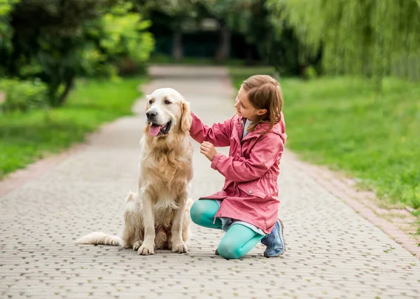 在公园里带着金毛猎犬的小女孩 — 图库照片